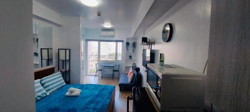 a living room with a blue bed in a room at De Luxe, Standard and Studio Suites -The Breeze Residences-close to Airport,Mall of Asia, US Embassy in Manila