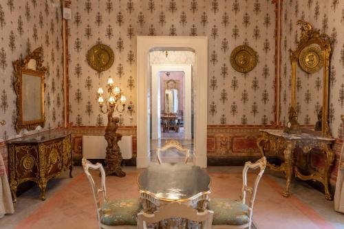 a room with a table and chairs and a mirror at Il Cavaliere al borgo antico in Copertino