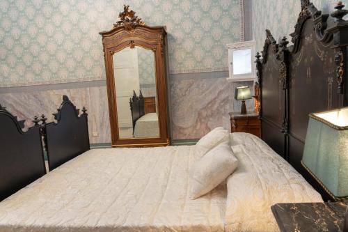 a bedroom with a large bed and a mirror at Il Cavaliere al borgo antico in Copertino