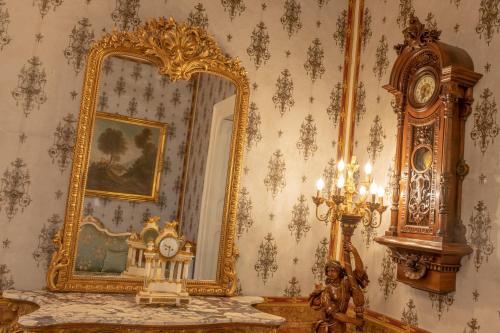 a room with a mirror and a clock on a table at Il Cavaliere al borgo antico in Copertino