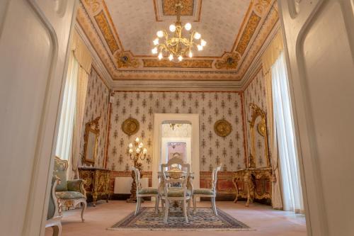 a dining room with a table and chairs and a chandelier at Il Cavaliere al borgo antico in Copertino