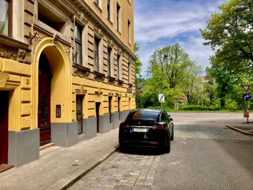 une voiture noire garée sur le côté d'un bâtiment dans l'établissement Jugendstil Apartment, à Vienne