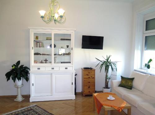- un salon avec une armoire blanche et un canapé dans l'établissement Jugendstil Apartment, à Vienne