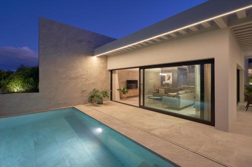 a swimming pool in front of a house at Salobre Oasis Suites in Salobre