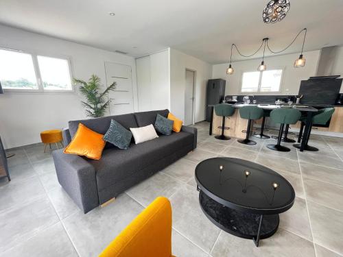 a living room with a couch and a table at Villa Les Romarins in Vallon-Pont-dʼArc