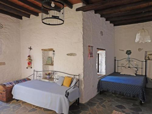 a bedroom with two beds and a chandelier at Philoxeno Traditional house - Ano Syros in Ano Syros
