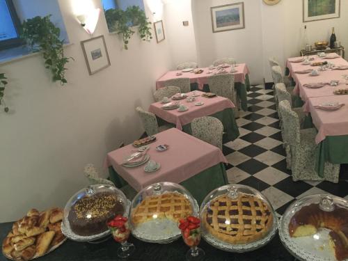 a dining room with pink tables and baskets of food at Hotel Villa Giulia in Tortona