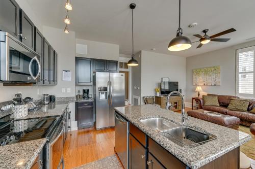 a kitchen with stainless steel appliances and a living room at Winston-Salem Vacation Rental - Walk Downtown! in Winston-Salem