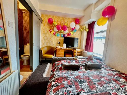 a bedroom with a bed with balloons on it at Blackpool Central Hotel in Blackpool