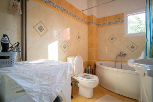 ein Badezimmer mit einer Badewanne, einem WC und einem Waschbecken in der Unterkunft Vacation House in Agiokampos in AgiaKampos