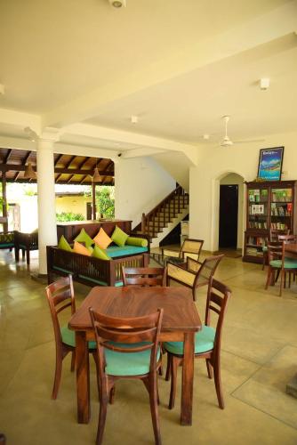 a dining room with a table and chairs and a couch at Kingfisher in Unawatuna