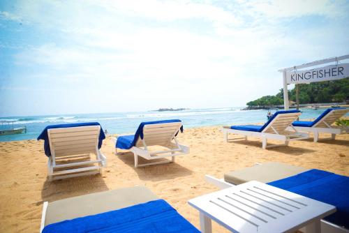 a group of chairs and tables on a beach at Kingfisher in Unawatuna