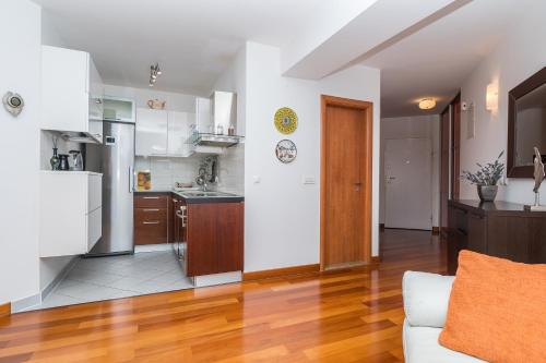 a kitchen and living room with white walls and wooden floors at Irisa Art in Makarska