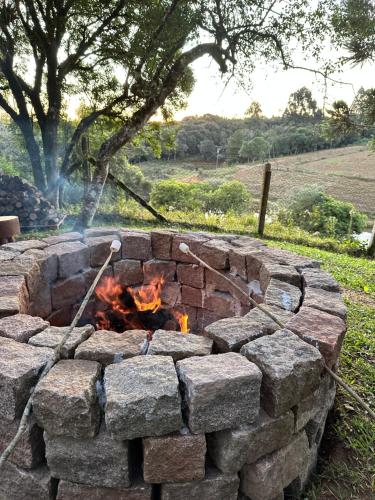 uma fogueira feita de tijolos num campo em CHALES CAMBARA DA SERRA em São José dos Pinhais
