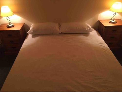 een slaapkamer met een bed met 2 nachtkastjes en 2 lampen bij Eastbourne Large Double Room with WiFi & Kitchen in Polegate