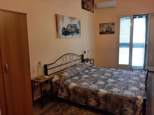 um quarto com uma cama e uma janela em Appartamenti Lascaris em Lascari