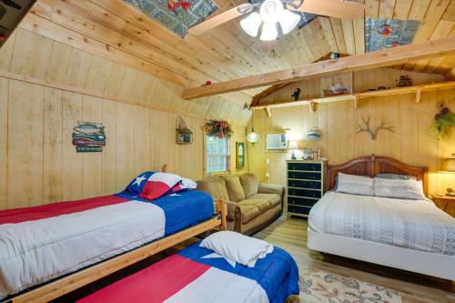 two beds and a couch in a room with wooden walls at Emory Studio Cabin with Lake Fork Boat Access! in Emory