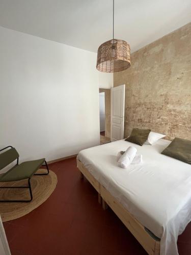 1 dormitorio con 1 cama blanca grande y 1 silla en "Le central" Appart Arles, en Arles