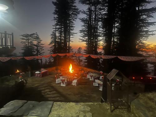 a group of tables and chairs in front of a fire at Norvin Homes in Shimla