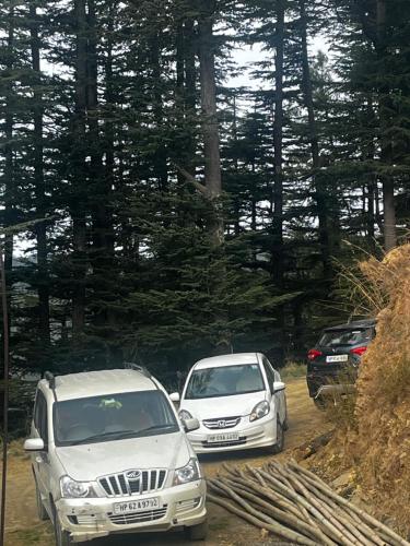 two cars parked next to each other on a dirt road at Norvin Homes in Shimla