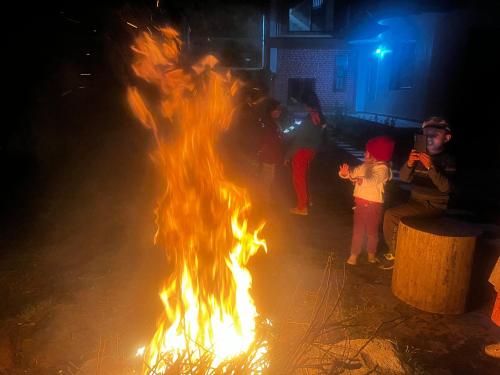 a group of people sitting around a fire at Norvin Homes in Shimla