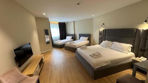 ein Hotelzimmer mit 2 Betten und einem TV in der Unterkunft Granda Hotel in Tirana