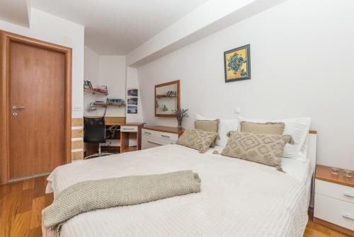 a bedroom with a large white bed with a desk at Irisa Art in Makarska