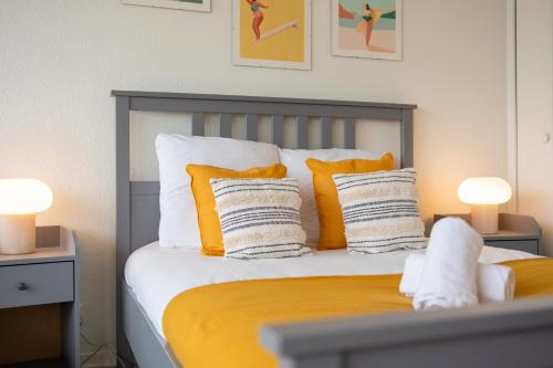 a bedroom with a bed with yellow and white pillows at Atlantic Selection - Vue panoramique sur l'océan avec Parking in Hendaye
