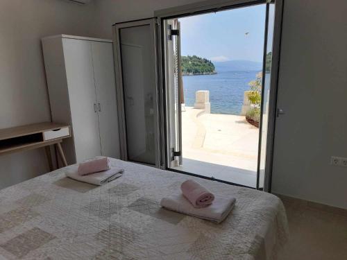 een slaapkamer met een bed en uitzicht op de oceaan bij Villa Elsi lower apartment in Kalámi
