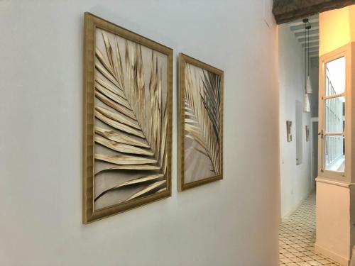 two framed pictures on a wall in a hallway at Precioso Apartamento: La Luz de Cádiz in Cádiz