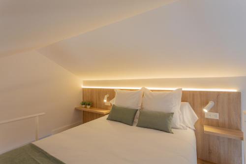 una camera con un letto bianco con due cuscini di Atico CL centro Granada a Granada