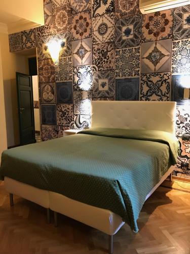 a bedroom with a bed and a wall of tiles at Hotel Giglio in Florence