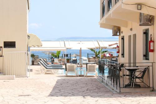 a patio with chairs and tables on a building at Stavros Beach Resort in Kavos