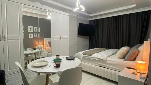 Schlafzimmer mit einem Bett, einem Tisch und Stühlen in der Unterkunft TC homes in Arnavutköy