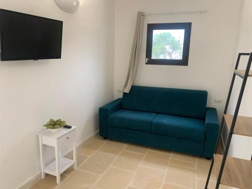 a living room with a blue couch and a tv at Dimora Salentus in Matino