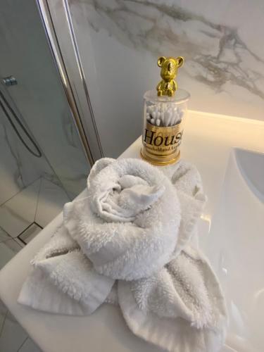 a pile of towels sitting on a bathroom counter with a bottle of honey at studio ilanit in Karmiel