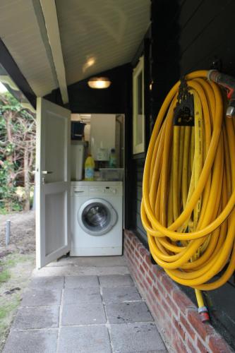 a group of yellow fire hoses hanging from a house at het Uylennest, uniek en goedkoop! in Hem