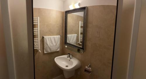 a bathroom with a sink and a mirror at Pensiunea Poiana Izvoarelor in Vatra Dornei