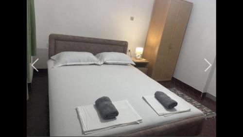 a white bed with two slippers on top of it at Apartmans sabovic in Ulcinj