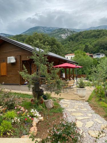 a house with a red umbrella and a patio at Guest House Mare in Bar