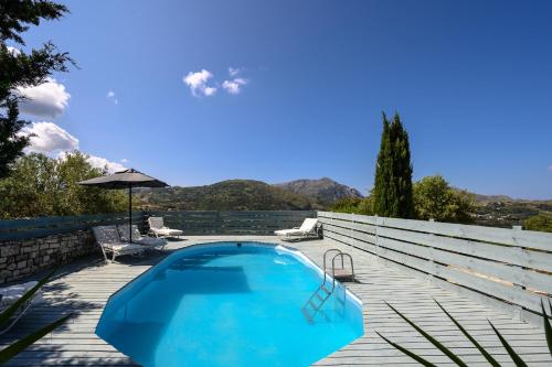 a blue swimming pool on a wooden deck at Rogalida in Lambiní