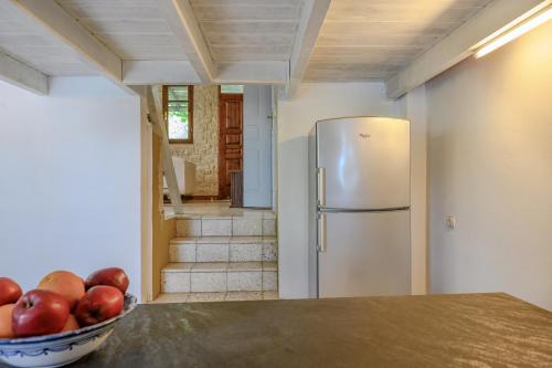 a kitchen with a bowl of apples and a refrigerator at Rogalida in Lambiní