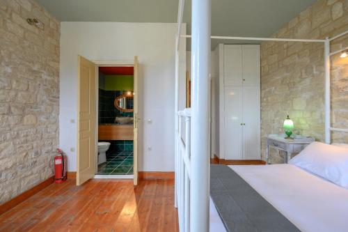 a bedroom with a bed and a room with a bathroom at Rogalida in Lambiní