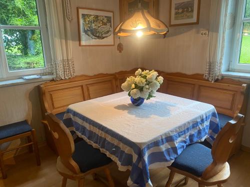 a dining room table with a vase of flowers on it at Apartment Thomabauerhof in Oberzeiring