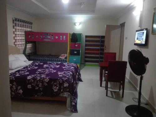 a bedroom with a bed and a table and chairs at Luxury Homes in Port Harcourt
