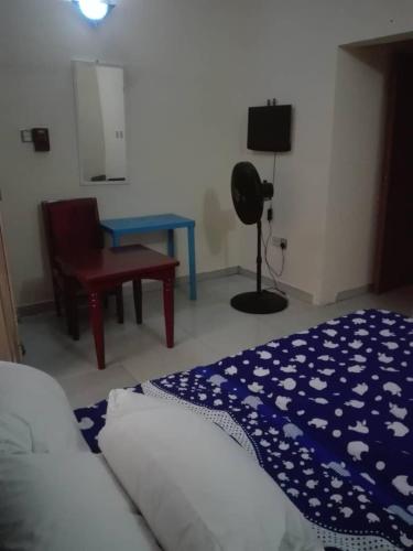 ein Schlafzimmer mit einem Bett, einem Stuhl und einem Tisch in der Unterkunft Luxury Homes in Port Harcourt