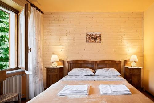 1 dormitorio con 1 cama con 2 toallas en Casa ai Lali, en Forno di Zoldo