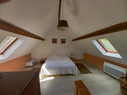 um quarto com clarabóias e uma cama no sótão em l antre pot em Arques-la-Bataille