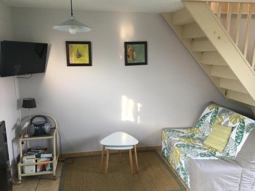 uma sala de estar com um sofá e uma televisão em l antre pot em Arques-la-Bataille