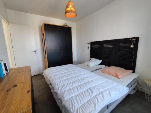 une chambre avec deux lits et un lustre dans l'établissement Villa de Jo, à Grand-Village-Plage